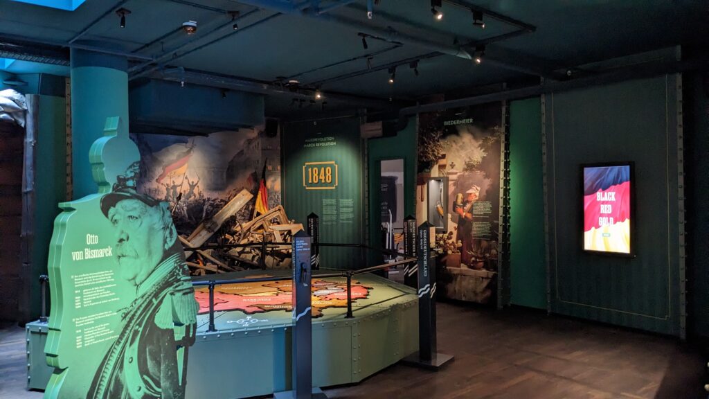 Komplett gestalteter Raum innerhalb des Deutschlandmuseums. Rechts Screen an der Wand mit dem Spiel Schwarz-Rot-Gold